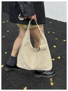 Detail of a large cream hobo tote bag with a small matching pouch in an autumn setting
