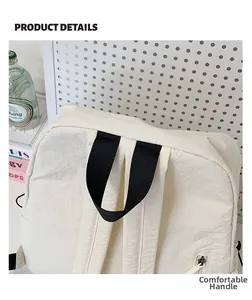 Detail of comfortable black nylon handle on minimalist cream commuter backpack