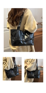 Macro view of a black glossy PU leather tote bag featuring vintage buckle strap details