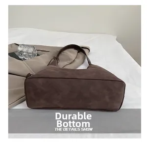 Vista ravvicinata del fondo ampio resistente di questa borsa tote in camoscio