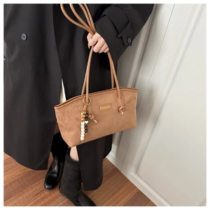 Detail of vintage brown suede tote bag with FASHION label and wooden bead charm