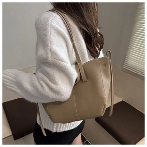 Back view of model wearing a khaki pebbled leather tote bag with long shoulder straps