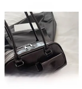 Detail of dark brown glossy leather Boston bag with double zippers and front flap pockets