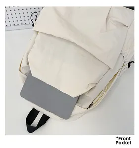 Front pocket of the cream nylon backpack holding a tablet to show its large storage capacity
