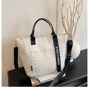 Macro shot of white puffer tote bag with black straps and adjustable shoulder strap detail