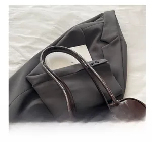 Detailed view of dark brown oil wax leather tote bag handle and glossy texture