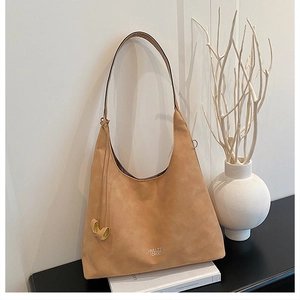 Dettaglio della borsa tote in pelle scamosciata con logo, nappa e design minimalista