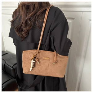 Close-up of brown suede tote bag featuring a retro beaded strap and fashion leather patch