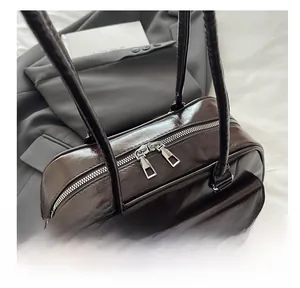 Detailed view of dark brown high-gloss bag with reptile texture strap and silver zippers