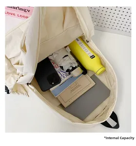 Detail view of large capacity backpack interior showing water bottle, tablet, and books