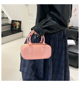 Detail of pink glossy PVC jelly Boston bag with shiny patent leather texture and gold hardware