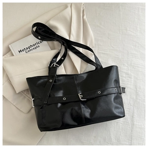 Detailed flat lay of black PU leather tote bag with metallic eyelet belt decorations