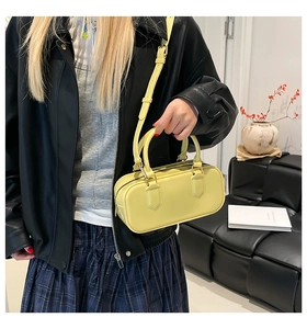 Detailed view of bright yellow rectangular Boston bag with adjustable shoulder strap