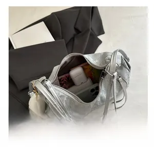 Silver wrinkled texture crossbody bag with cat charm showing spacious interior storage