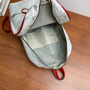 Detail view of the silver backpack interior with grey lining and red patent leather straps