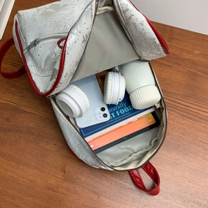 Top view of silver floral backpack interior showing spacious storage for tablet and books