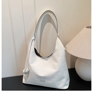 Dettaglio della borsa hobo in pelle bianca con ciondolo a nodo e logo del marchio