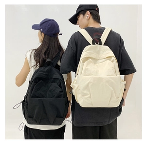 Rear view of black and beige large capacity nylon backpacks on a young male and female couple