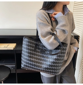 Detail of large tote bag featuring geometric patterns and black leather brand plaque
