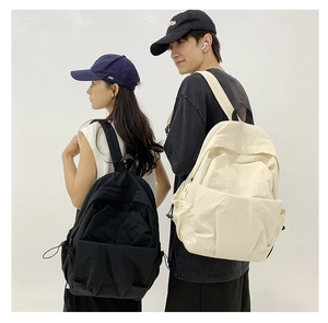 Detail of minimalist large capacity nylon backpacks in black and cream colors