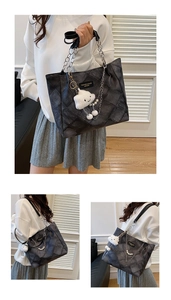 Detail of quilted tote bag with metal chain, pearl strap and plush cloud charm