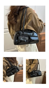 Detail of black glossy shoulder bag featuring double front flap pockets and silver hardware