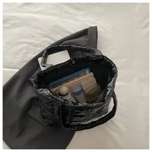 Macro detail of spacious black quilted tote bag showing high capacity storage inside