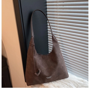 Dettaglio della borsa hobo in pelle scamosciata marrone scuro con logo su tessuto