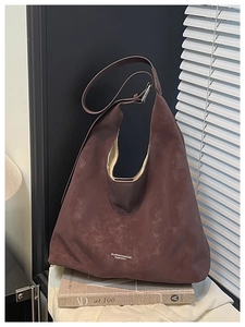 Close-up of a large dark reddish-brown matte faux suede tote bag with white lettering