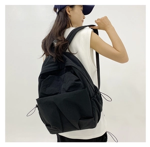 Detail view of large black nylon backpack with side drawstring and spacious main compartment