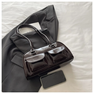 Macro detail of glossy dark brown PU leather shoulder bag with two front flap pockets