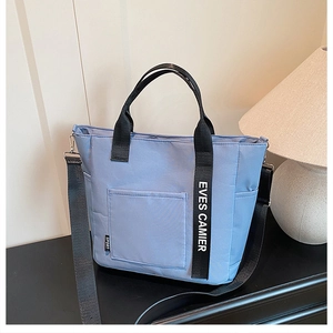 Light blue canvas lunch bag with adjustable shoulder strap and large capacity pocket