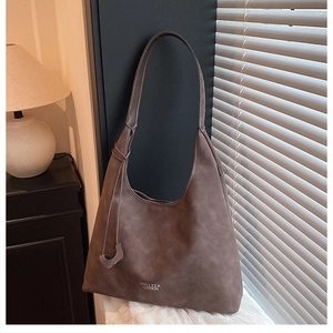 Dettaglio della borsa tote in pelle scamosciata marrone con logo su pelle opaca pregiata