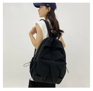 Close-up of black nylon large capacity backpack featuring functional side drawstrings
