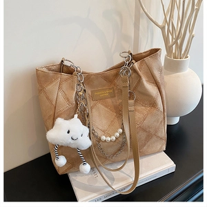 Detail of khaki quilted tote bag with pearl chain strap and cloud plush charm
