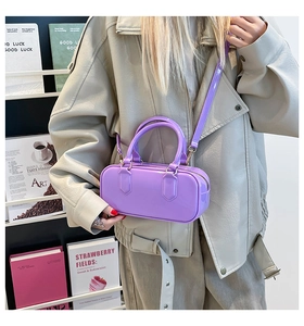 Detailed shot of the purple glossy patent leather crossbody bag with top handles