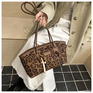 Detailed macro view of fashion leopard print tote bag with beaded strap ornament
