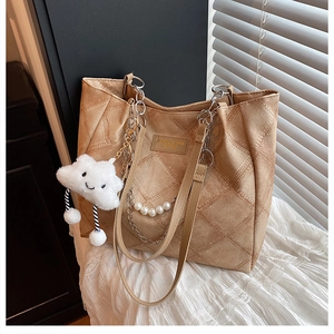Detail of khaki quilted tote bag with silver chain, pearl handle and cloud charm
