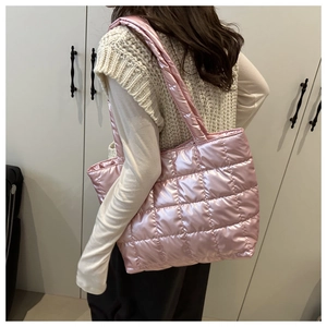 Side view of pink quilted tote bag with metallic finish shown on model for size scale