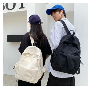 Couples wearing stylish large capacity nylon backpacks in black and cream beige colors