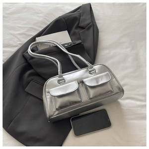 Detail view of silver mirror leather shoulder bag with double pockets on office blazer