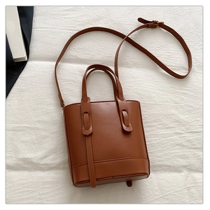 Détail d'un sac seau en cuir marron avec boucle à anneau et bandoulière réglable
