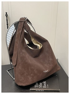 Macro detail of brown suede hobo bag with adjustable silver buckle and logo branding