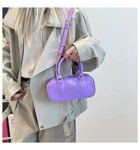 Detail of glossy purple crossbody bag with circular handle and polished finish