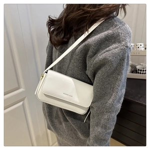 Close-up of a white patent leather shoulder bag featuring the KEKEDOU & BAG logo engraving