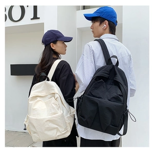 Detail view of large capacity nylon pleated backpacks worn by a couple for travel