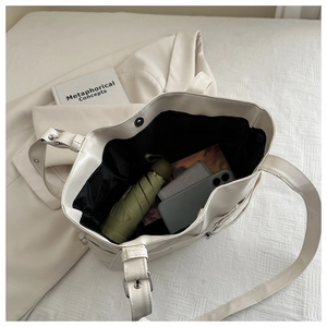 Interior view of ivory tote bag showing storage for umbrella, phone, and wallet