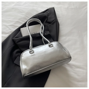 Detail of silver metallic handbag with soft leather texture on a minimalist background