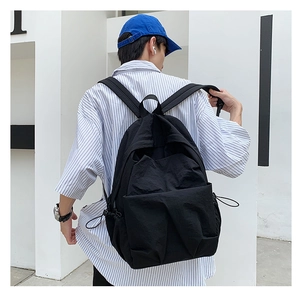 Detailed view of a large black waterproof nylon backpack with drawstring side pockets