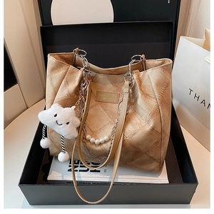 Beige quilted tote bag with chain strap and cute charms displayed in a premium gift box